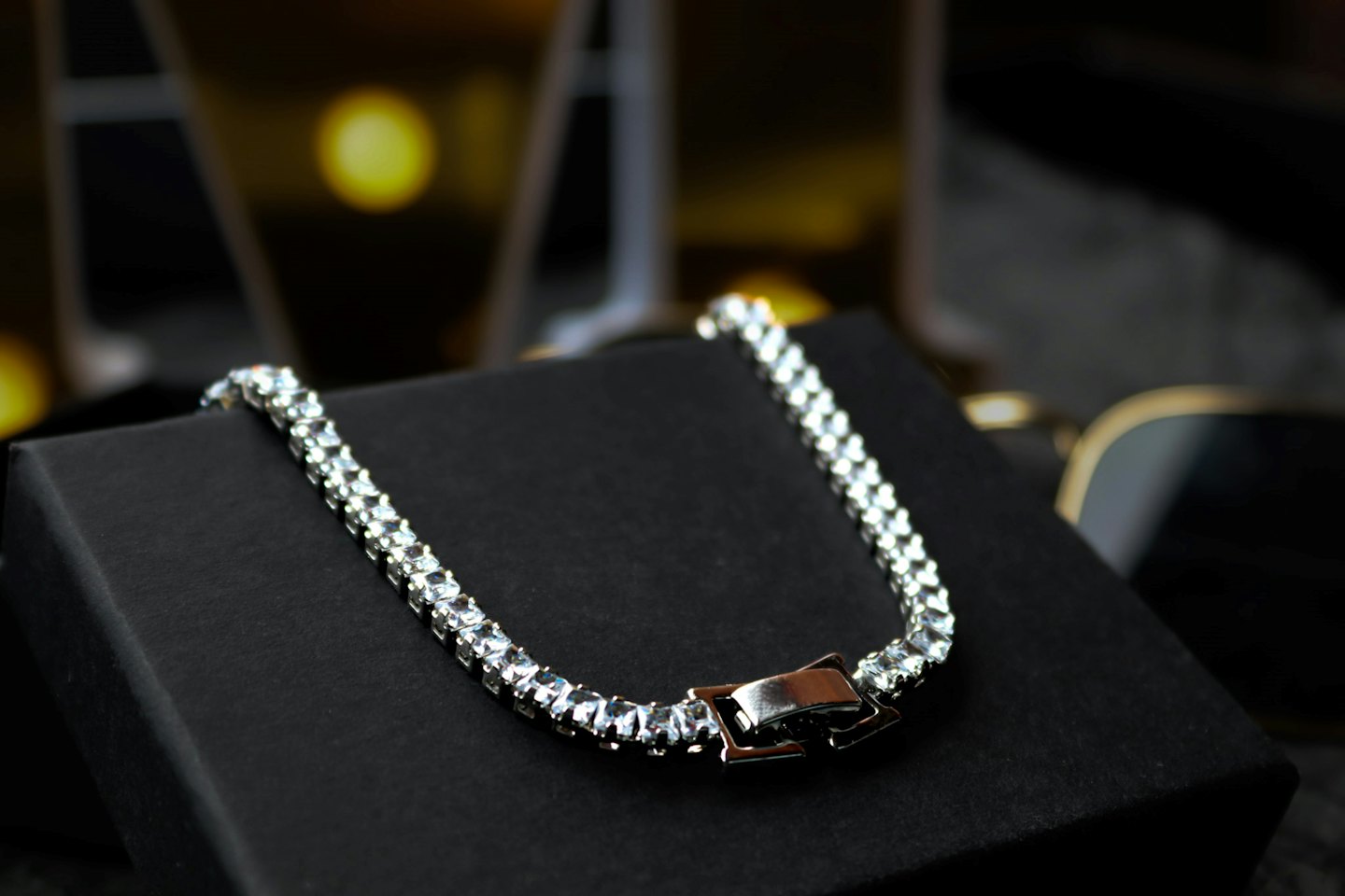 Bracciale d'argento con pietre trasparenti su scatola nera.